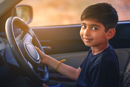Cute Indian child in carの写真素材