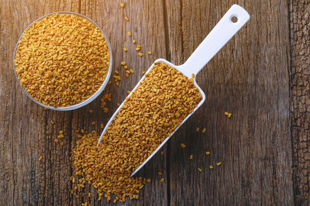 Fenugreek seeds on wooden backgroundの写真素材