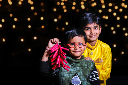 Cute Indian child celebrating Diwali festival with cracker and sparkleの写真素材