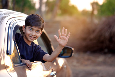 Cute Indian Child waving from car windowの写真素材