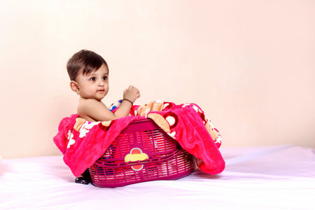 Cute indian baby sitting in shopping basket