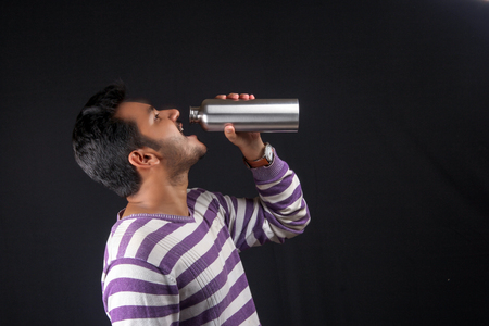 Indian man drinking water with bottleの写真素材