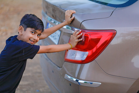 Cute Indian child with carの写真素材