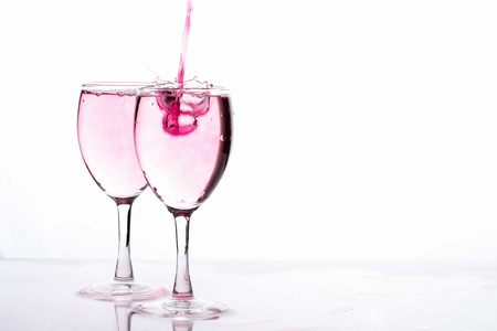 Red food coloring diffuse in water inside wine glassの写真素材