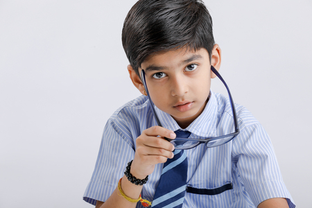 Cute little Indian / Asian school boy wearing uniform and spectaclesの写真素材