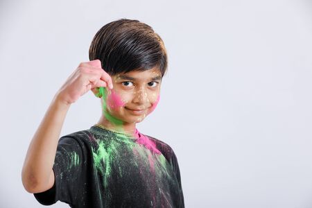 Indian little boy playing with the color and giving multiple expressions in holi festivalの写真素材