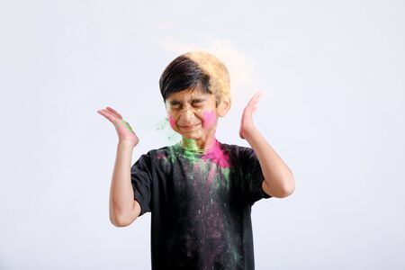 Indian little boy playing with the color and giving multiple expressions in holi festivalの写真素材