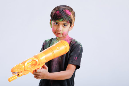 Indian Child playing holi with color gun