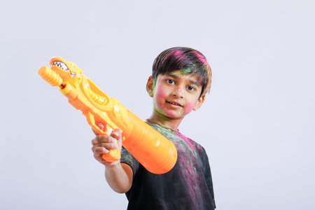 Indian Child playing holi with color gun