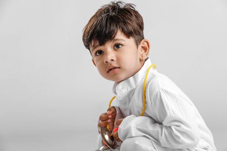 Indian Little Boy in Traditional Dress and learning Musical instrumentの写真素材