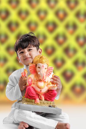 Little Indian boy with lord ganesha , Celebrating Ganesh Festivalの写真素材