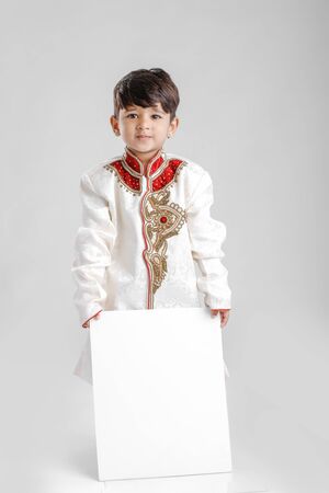 Indian / Asian little boy in ethnic wear and showing blank Signboardの写真素材