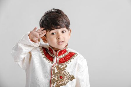Cute Indian / Asian little boy in ethnic wear and Saluting national flagの写真素材