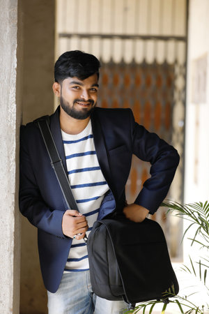 Young Indian male model standing and holding the office bag