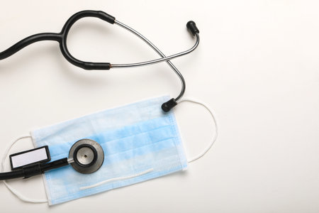 Corona virus outbreaking, Phonendoscope and Mask on white background