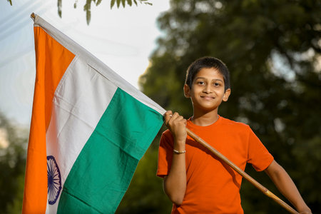 little indian child holding, waving or running with Tricolour flag