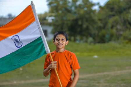 little indian child holding, waving or running with Tricolour flagの写真素材