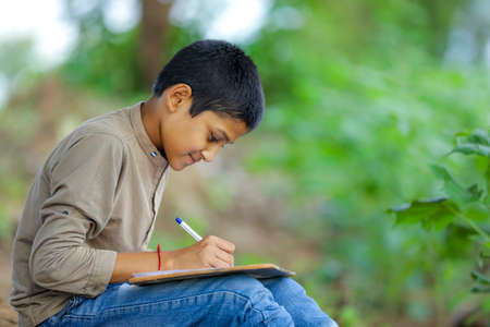 Indian child writing on note bookの写真素材