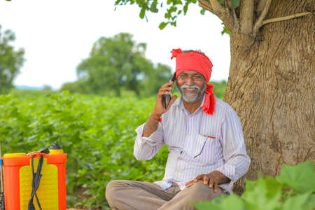 Indian farmer talking mobile phone at Agriculture fieldの写真素材