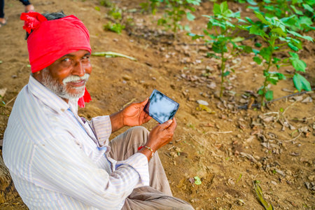 Indian farmer using mobile phone at Agriculture field