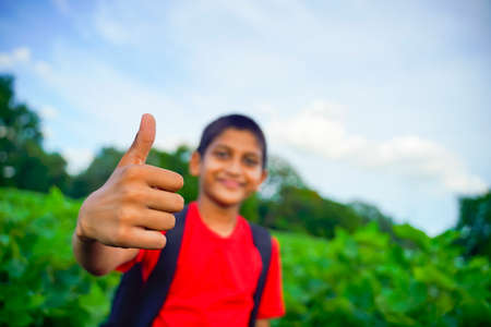 little Indian / Asian boy showing thumbs up , selective focus on handの写真素材