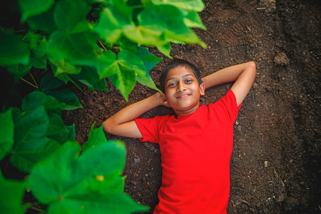 Smiling cute indian boy laying on ground