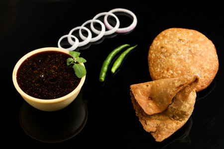 Kachori and potato samosa with green chilly. famous spicy snack in indiaの写真素材