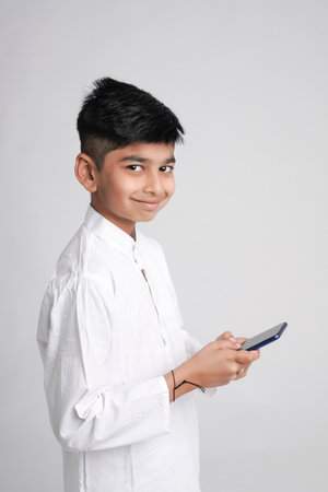Cute Indian little boy using smart phoneの写真素材