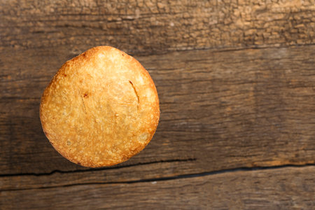 Kachori and coriander on wooden background.kachori is a spicy snack from India also spelled as...