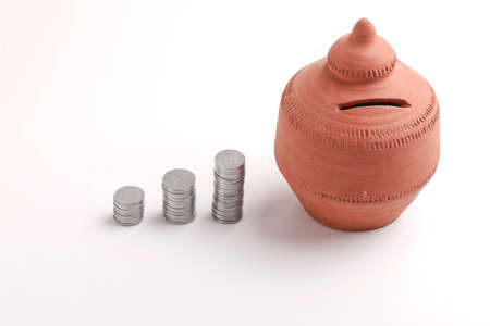 Clay piggy bank pot with Indian rupees coin over white background. saving conceptの写真素材