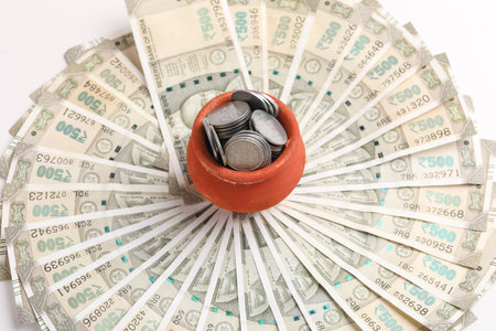 Clay piggy bank pot with five hundred indian rupees bank note on white backgroundの写真素材
