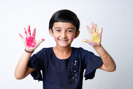 Happy Holi Greeting - Cute little Indian girl with colourful hands, isolated over white backgroundの写真素材