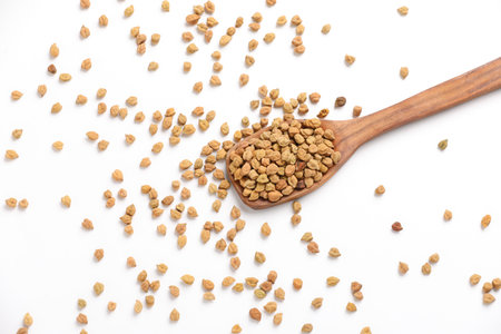 Dry raw organic chickpeas in a wooden spoon isolated on white background.