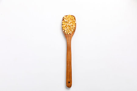 Dried chickpeas in wooden spoon isolated on white background.