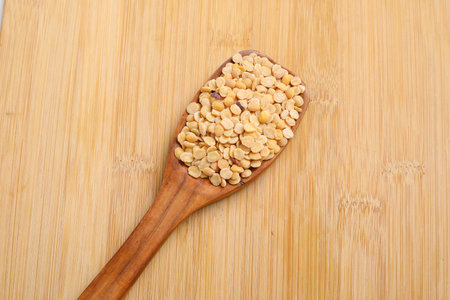 Unpolished Pigeon pea also known as toor dal in a wooden spoon.