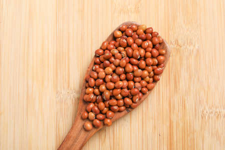 Pigeon pea in wooden spoon on wooden backgroundの写真素材