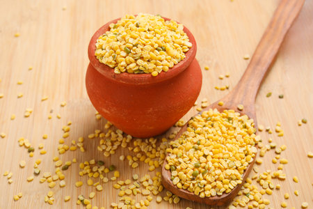 yellow moong mung dal lentil pulse bean in wooden bowl on wooden background.の写真素材