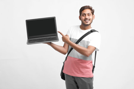 Indian college student showing laptop screen on white background.