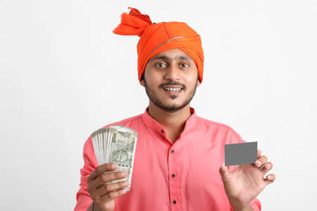 Young Indian farmer posing with currency on white background.の写真素材