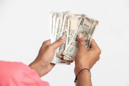 Indian man counting newly launched indian five hundred rupees. Money counting background business concept on white backgroundの写真素材