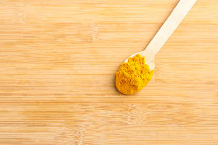 Turmeric in wooden spoon on white background.の写真素材