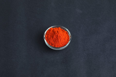 Dried red chilli and powder in glass bowl on dark background.の写真素材