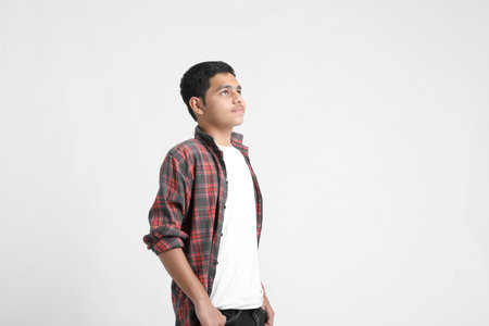 Young indian boy in a casual outfit and showing expression on white background.の写真素材