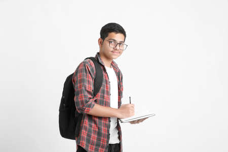 Education concept : Indian college student writing some notes in notebook on white background.の写真素材