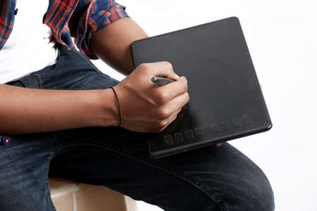 Professional designer using graphic tablet connected to smartphone with digital pen.の写真素材