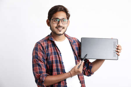 Young indian Professional designer showing graphic tablet with digital pen.の写真素材