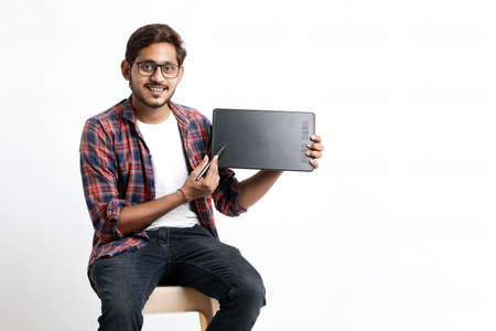 Young indian Professional designer showing graphic tablet with digital pen.の写真素材