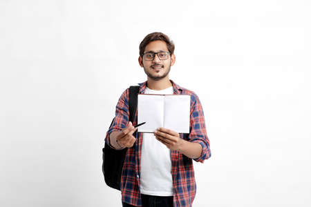 Education concept : Indian college student holding bag and showing note book on white background.の写真素材