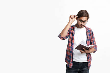 Young handsome indian college student giving thinking expression on white backgroundの写真素材