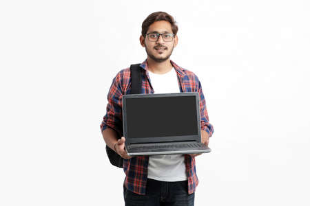 Indian college student showing laptop screen on white background.の写真素材